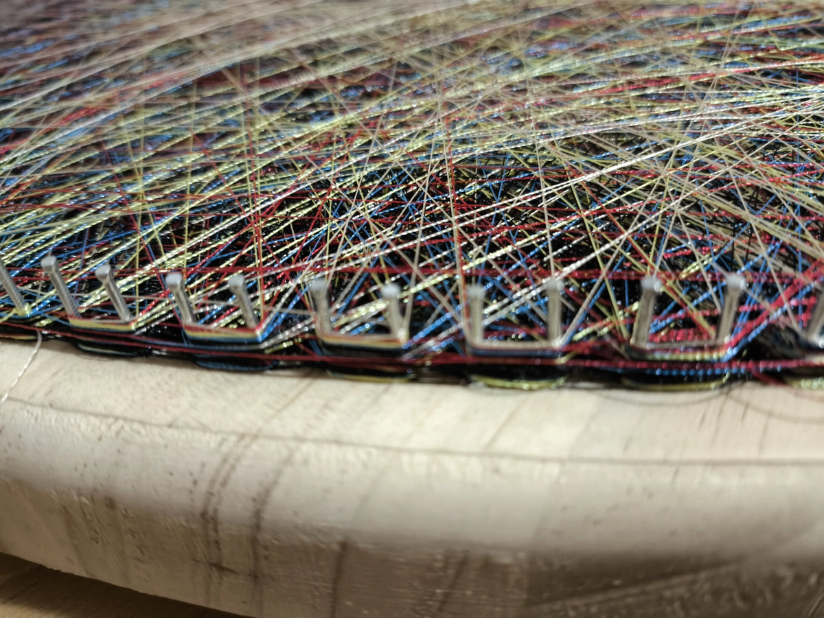 Close-up of thread, nails and timber in handmade string art