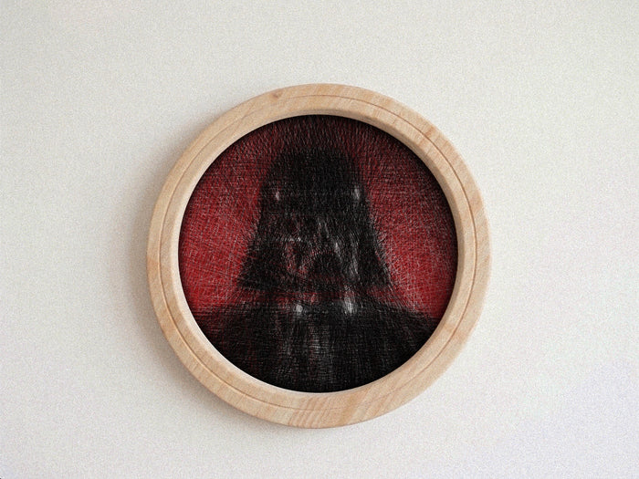 A circular wooden-framed wall string art piece featuring a dark, shadowy Darth Vader-like figure against a red background, mounted on a plain light wall.