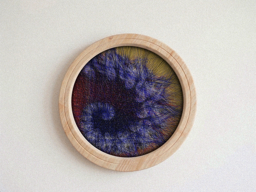 A circular wooden framed abstract string art piece featuring textured, needlepoint-like threads in shades of blue, purple, red, and yellow on a light beige background.
