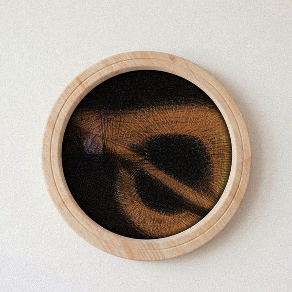 A circular wooden-framed string art artwork featuring a dark abstract design with warm brown and tan textured lines, mounted against a plain off-white wall.